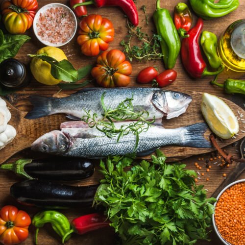 Raw uncooked seabass fish with vegetables, grains, herbs and spices on chopping board over rustic wooden background “Fueling Your Mind: The Power of Diet in Managing Depression”